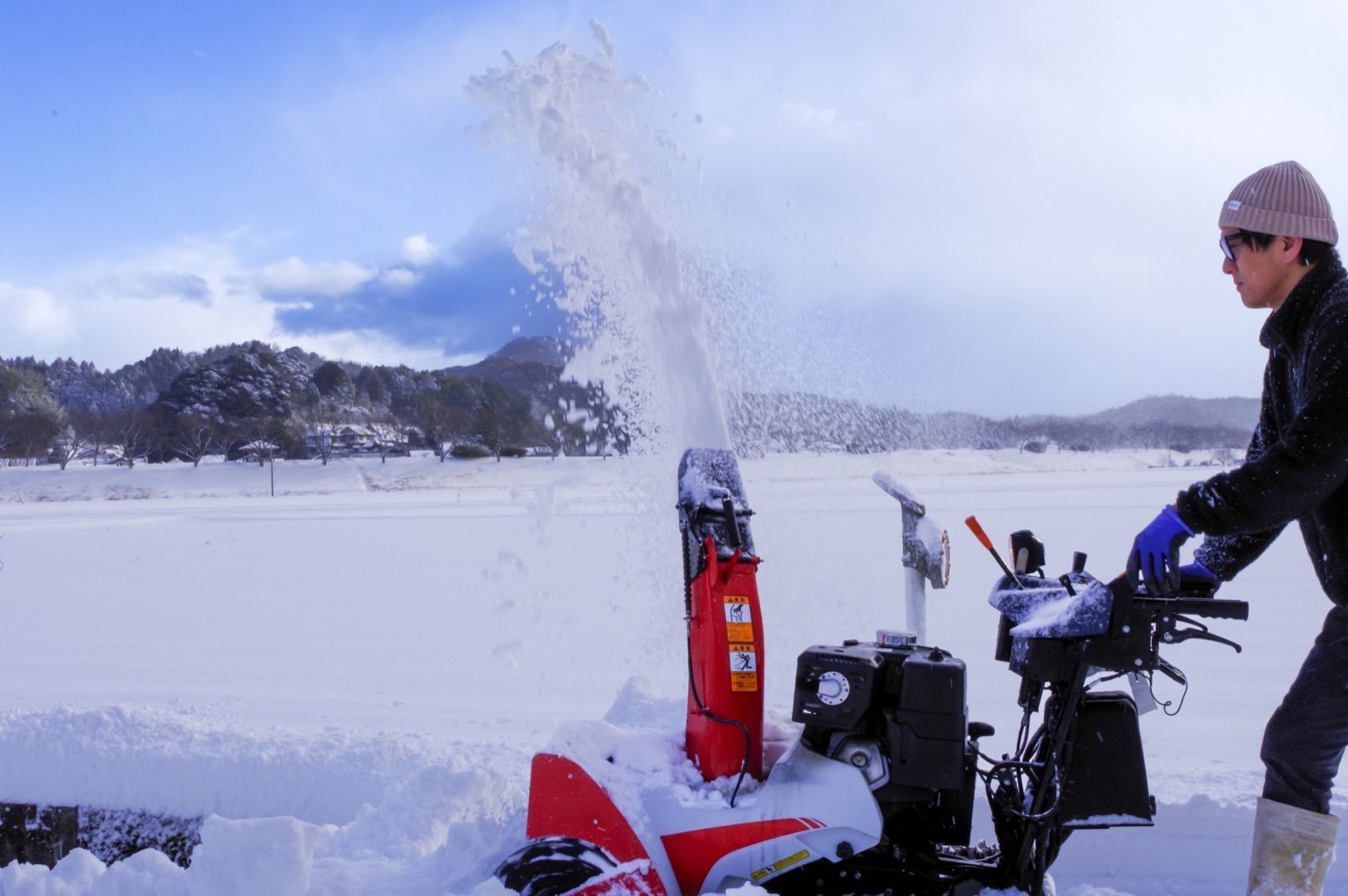 雪景色の中で除雪機を操作する様子(イメージ写真)