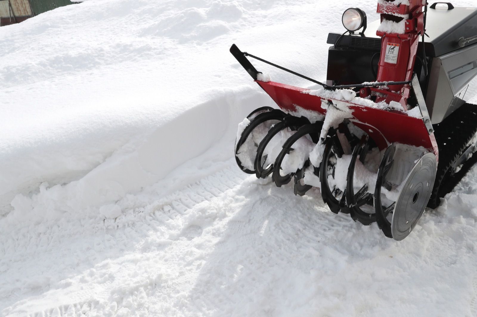 雪の中に置かれた除雪機の回転部(イメージ写真)